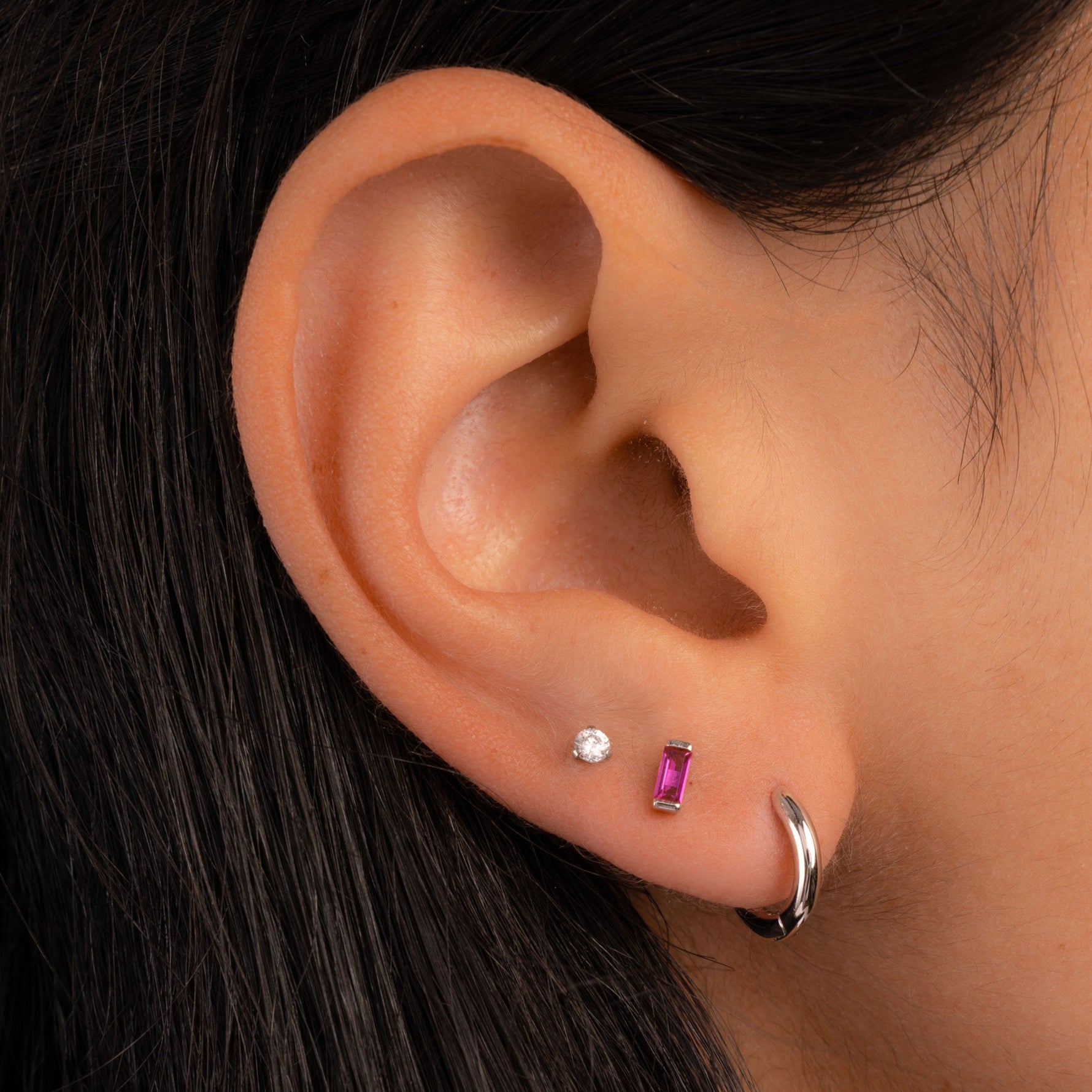 model wearing silver earrings and ruby gemstone earring