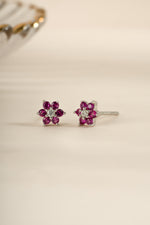 Sami Jewels ruby flower stud earrings with CZ center stone in sterling silver, featuring detailed petal design and sparkling gemstones.