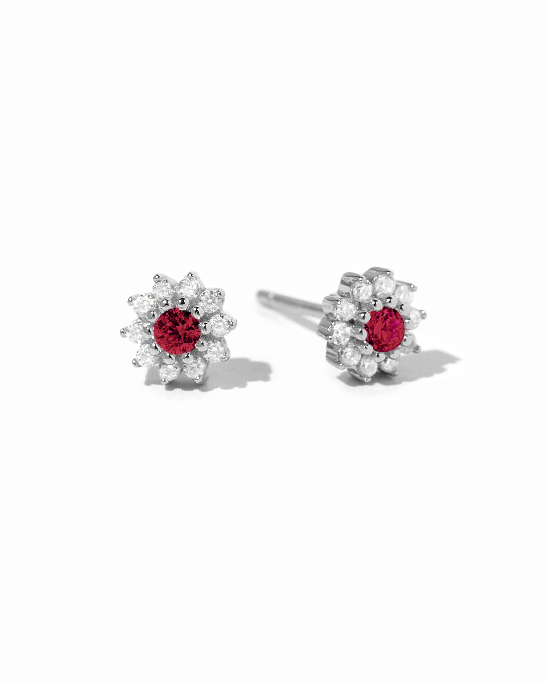 Sterling silver Ruby Dainty Flower Stud Earrings by Sami Jewels with small red ruby flower design on a white background