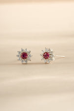 Sterling silver ruby dainty flower stud earrings by Sami Jewels, featuring small floral design with vibrant red rubies.