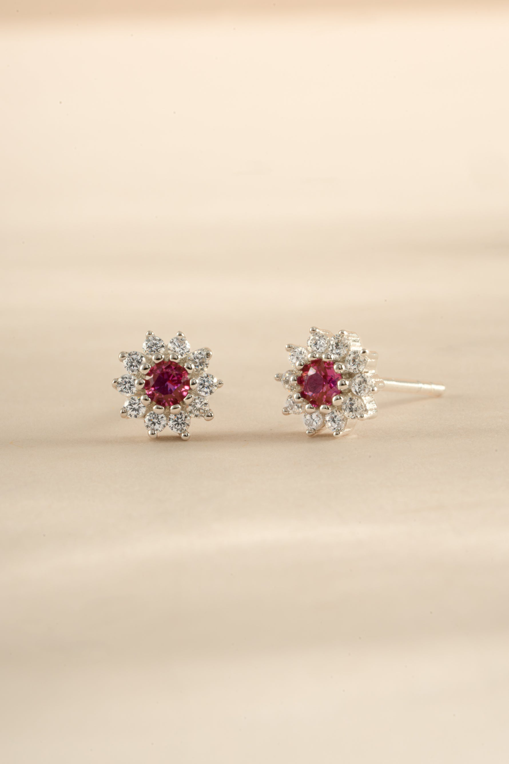 Sterling silver ruby dainty flower stud earrings by Sami Jewels, featuring small floral design with vibrant red rubies.