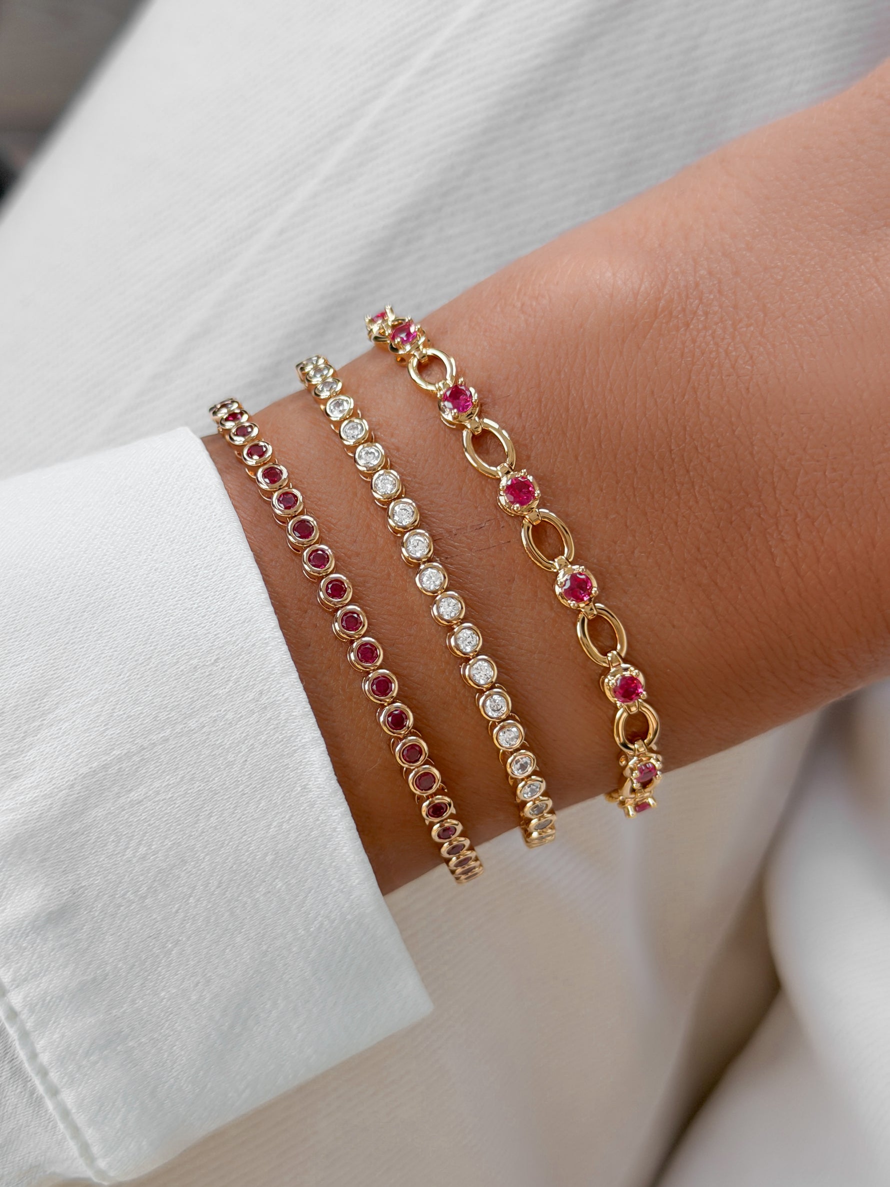 Gold Sami Jewels Ruby Lilly Tennis Bracelet with diamond accents worn on a wrist, showcasing elegant jewelry design.