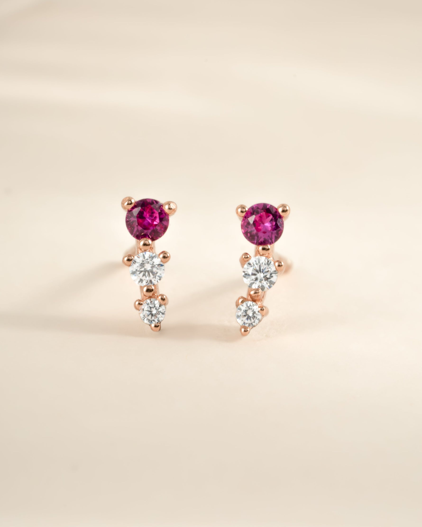Close-up of Sami Jewels ruby and diamond ear climber earrings in rose gold, showcasing vibrant rubies and sparkling diamonds.