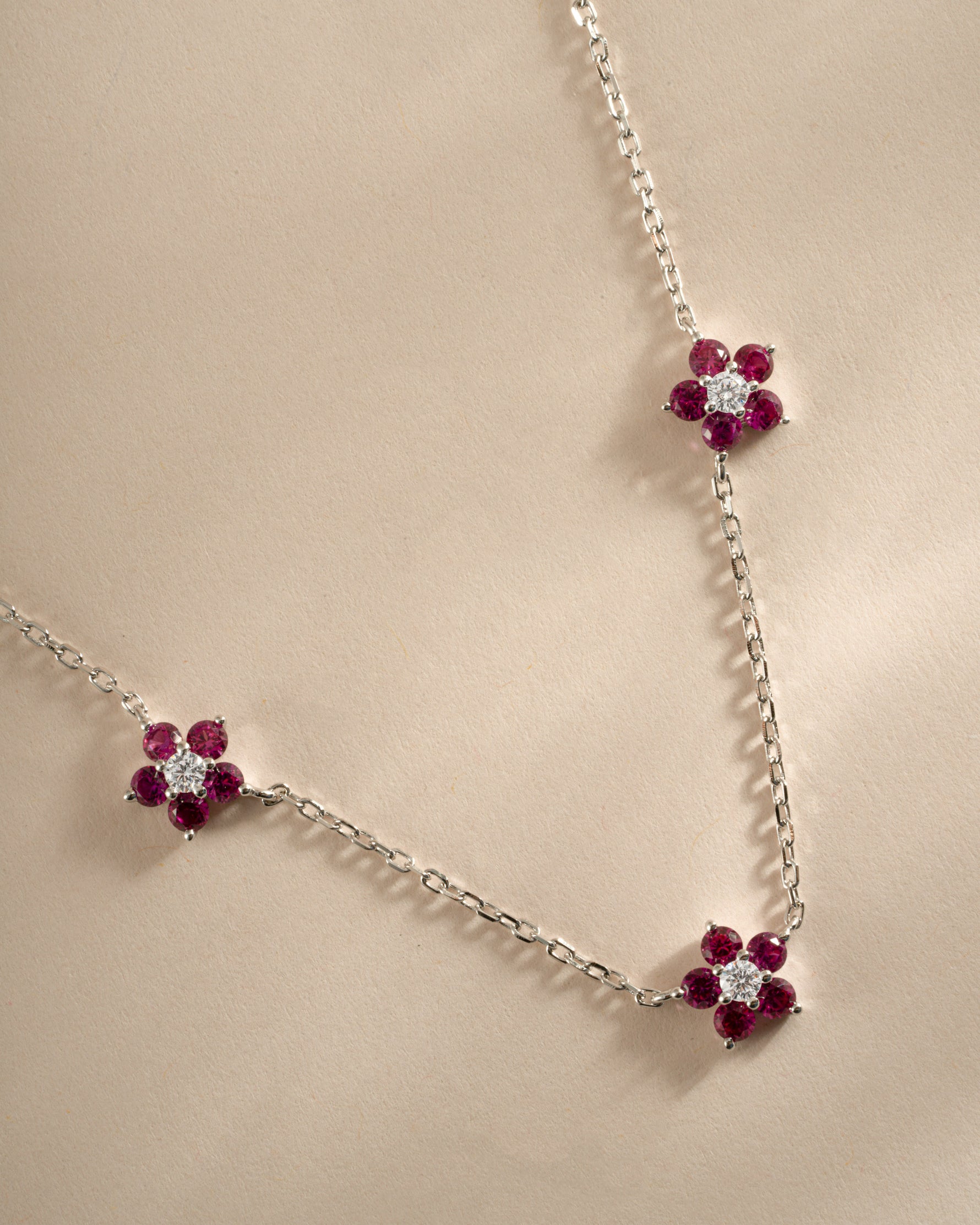 Close-up of Sami Jewels Ruby Flower Necklace featuring a sterling silver chain and a detailed ruby flower pendant.