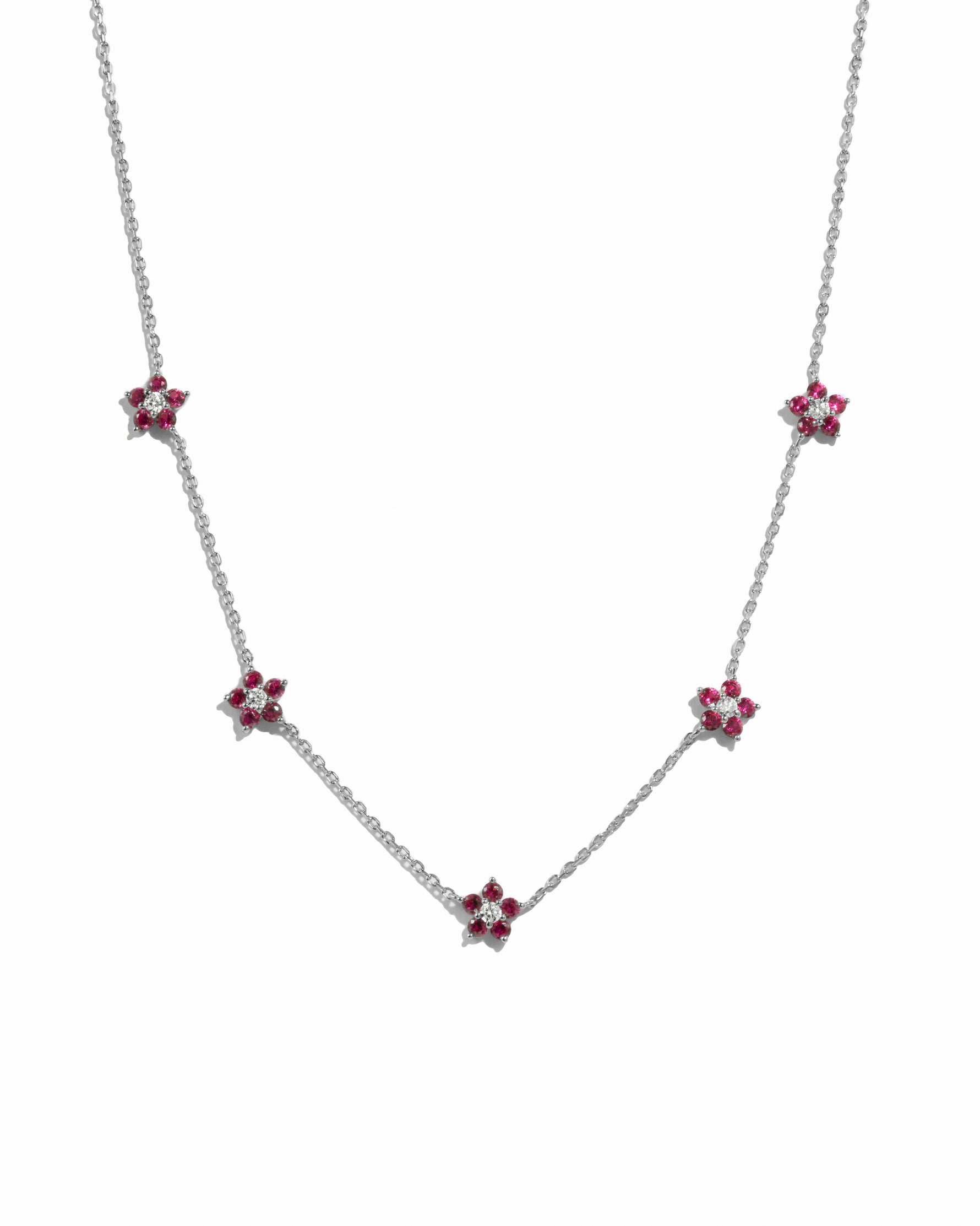 Sterling silver necklace with a ruby flower charm from Sami Jewels, displayed on a white background.