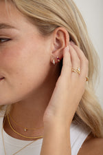 ruby three stone huggie gold earring stack on model