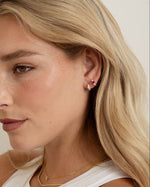 ruby three stone huggie earring on womens ear with gold jewelry