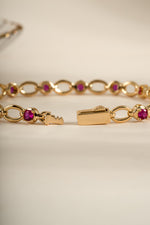 Gold Ruby Lilly Tennis Bracelet by Sami Jewels with a box clasp, featuring vibrant rubies and a sleek bracelet design.