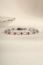 Silver Ruby Lilly Tennis Bracelet by Sami Jewels featuring a row of sparkling rubies on a sleek silver band.