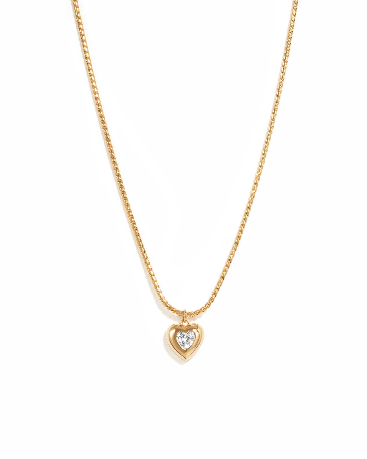 Gold heart necklace on white background