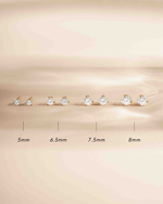 Gold bridal earrings featuring four pairs of gold stud earrings on a beige background.