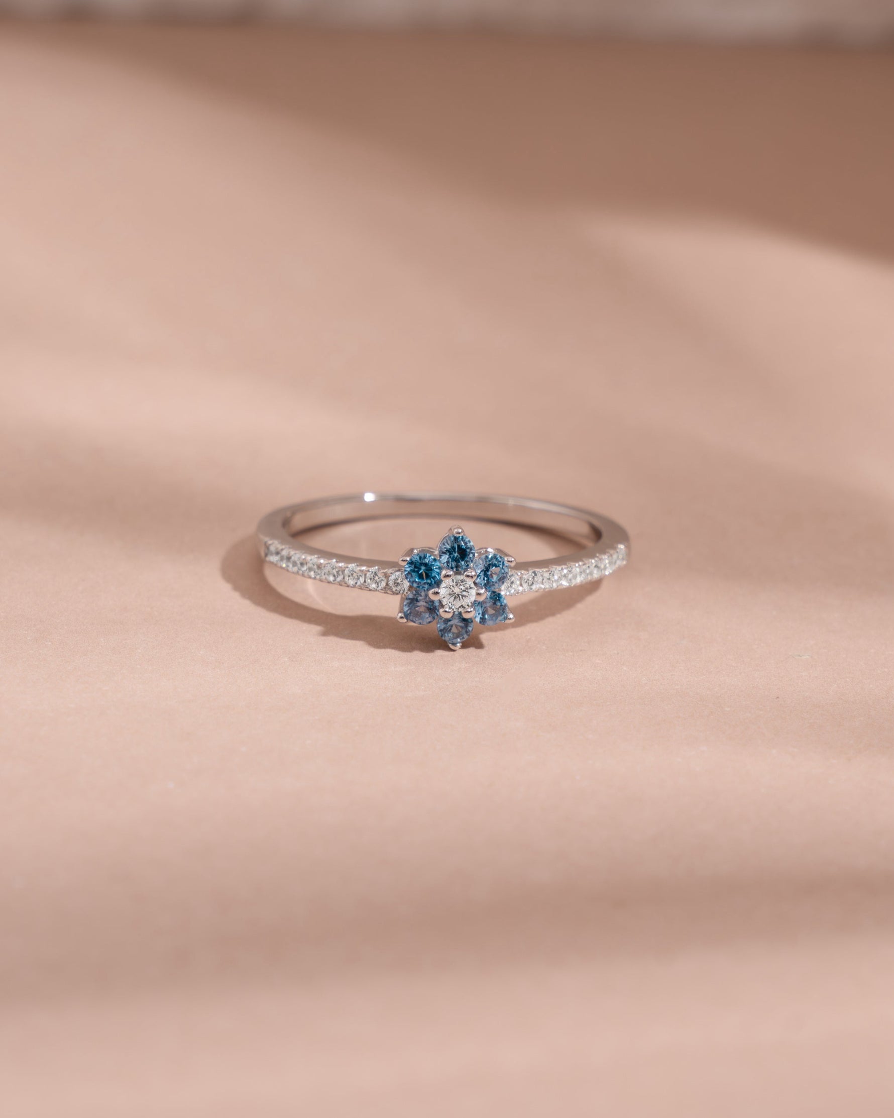 sterling silver ring with aquamarine blue gemstone on a beige fabric background