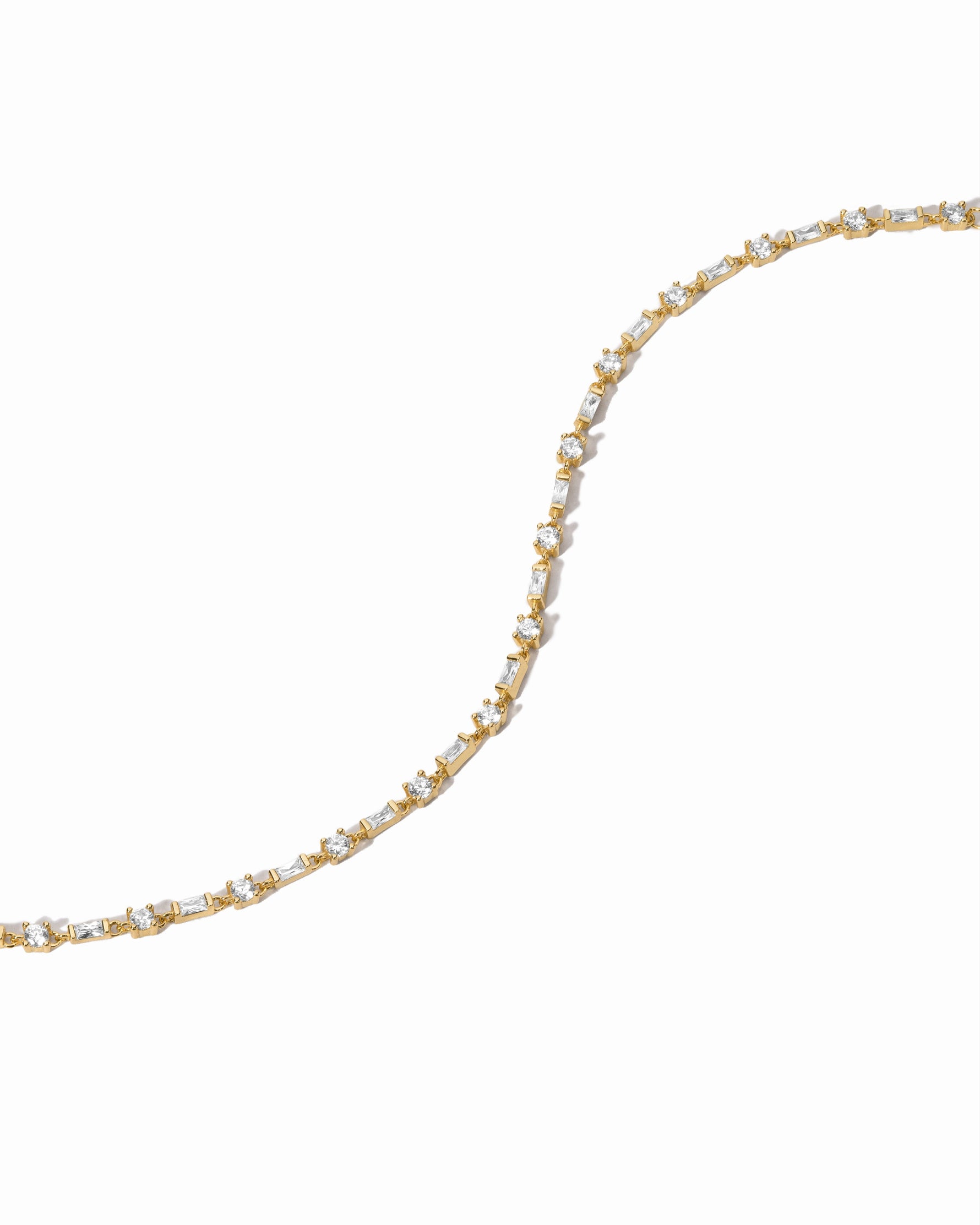 Delicate gold bracelet with small diamonds on a white background