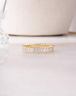 Gold ring with baguette-cut diamonds on a white surface