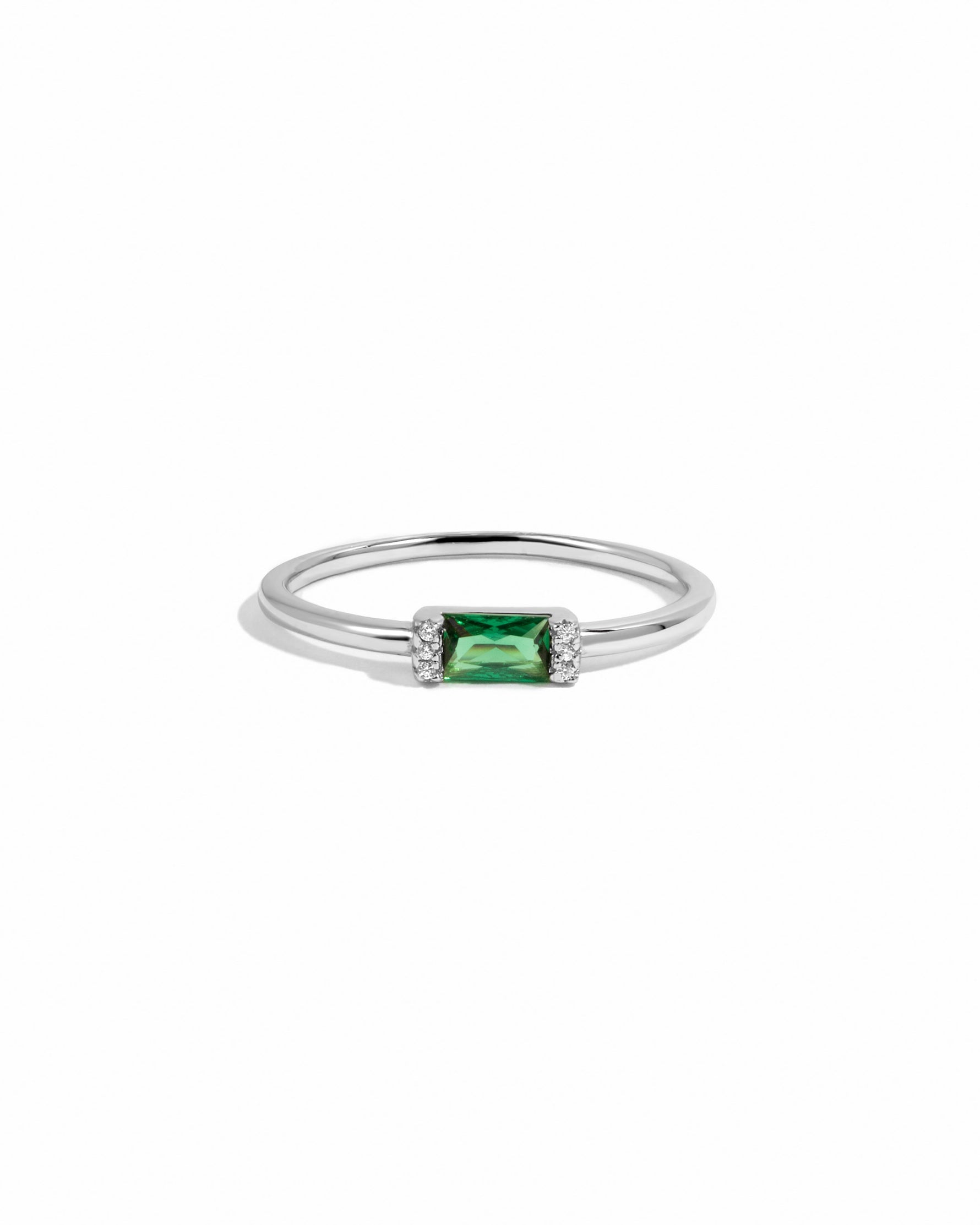 closeup image of sterling silver baguette ring with an emerald stone