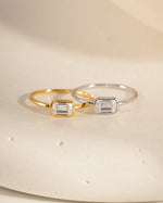 Two rings, one gold and one sterling silver with a bezel set stone