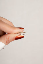 Model holding thin dainty gold and silver stacking rings. 