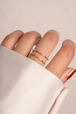 Model wearing stacked gold and silver thin plain band.