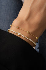 model wearing beaded bracelet and heart tennis bracelet