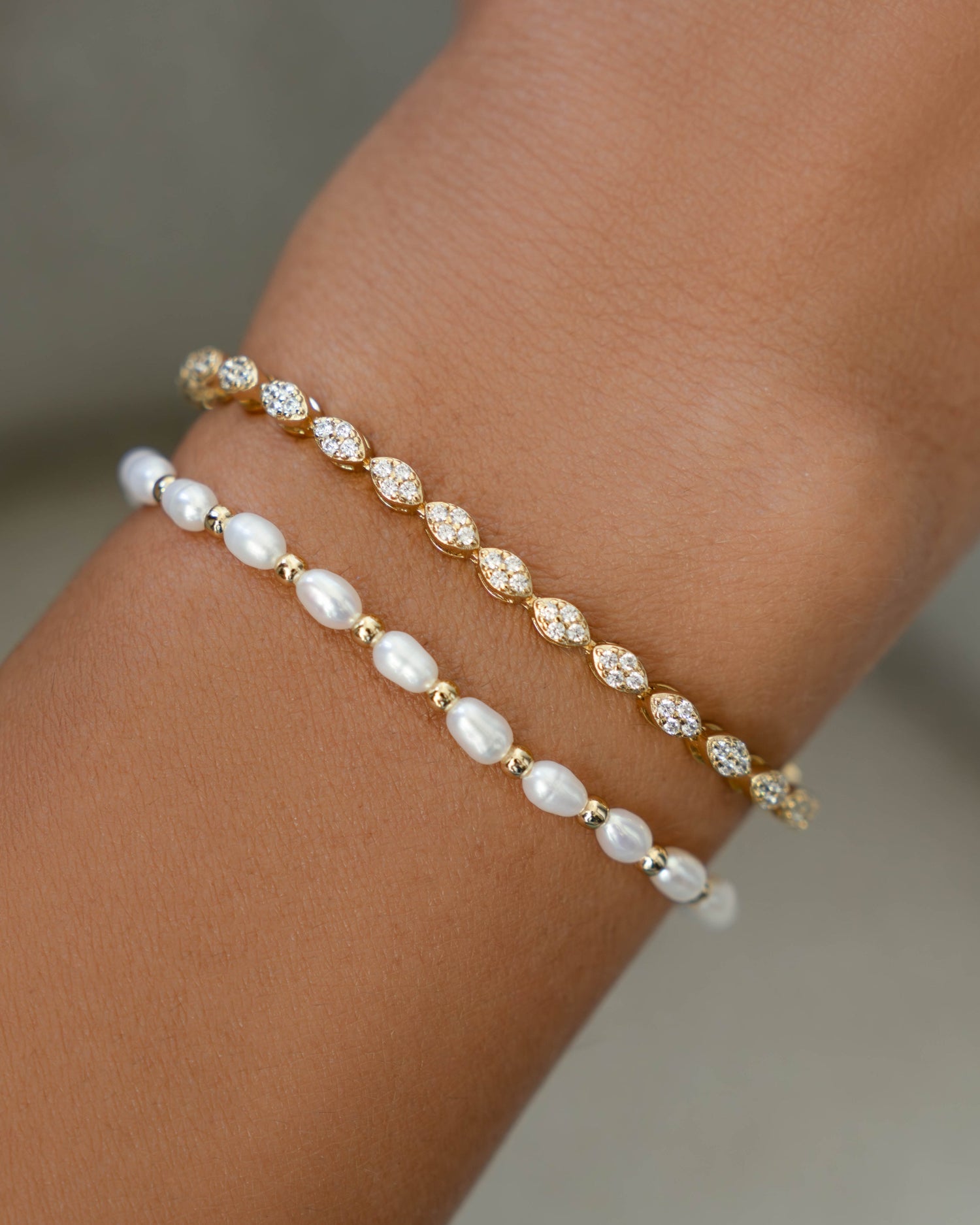 Freshwater pearl beaded bracelet and marquise cut diamond tennis bracelet on wrist