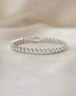 closeup image of tennis bracelet with oval bezel set diamonds 
