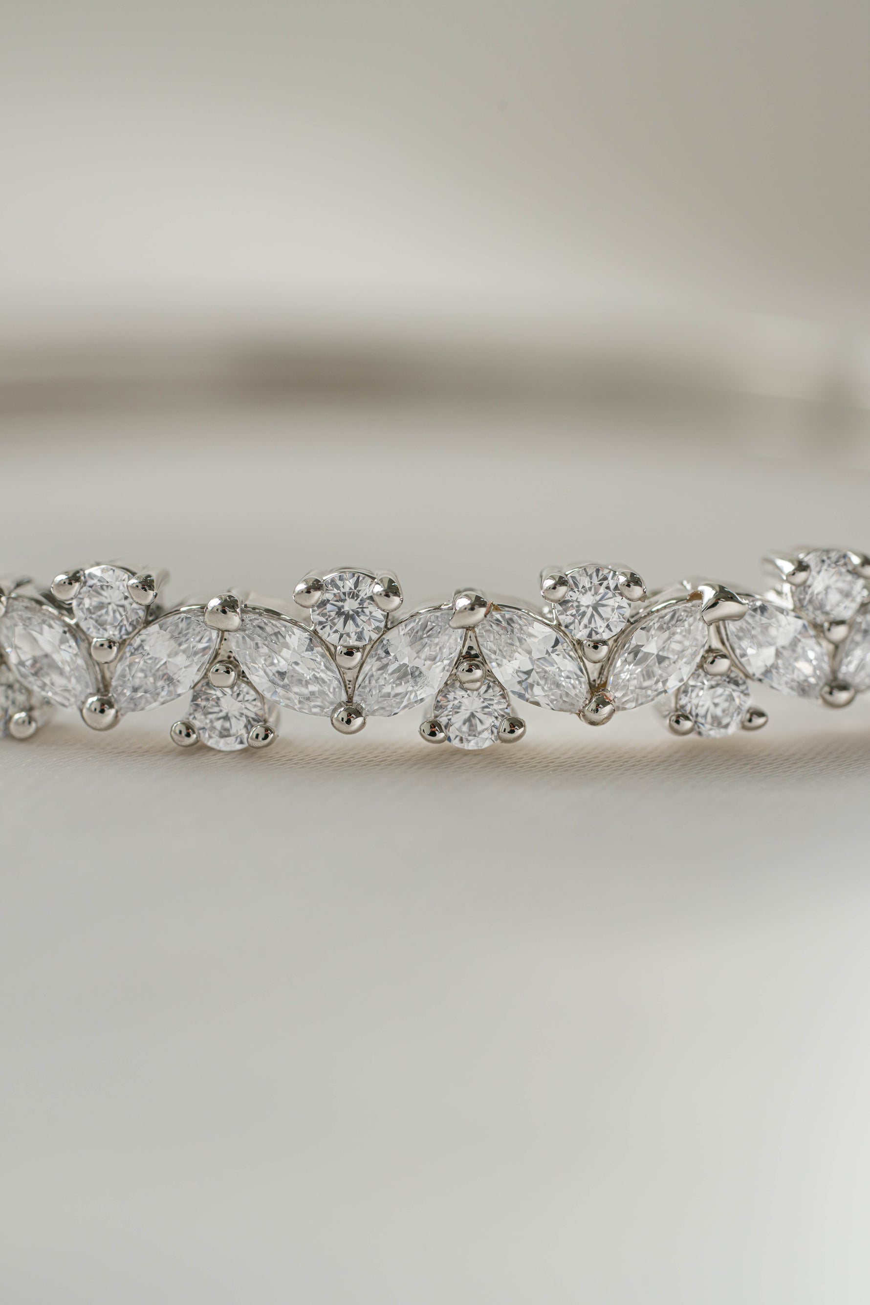 Closeup image of cubic zirconia diamonds from a silver diamond bracelet on a light background