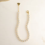 closeup image of dainty gold stacking bracelet featuring tennis bracelet design 