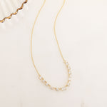 Closeup flatlay image of minimalist gold necklace with delicate cubic zirconia diamonds 