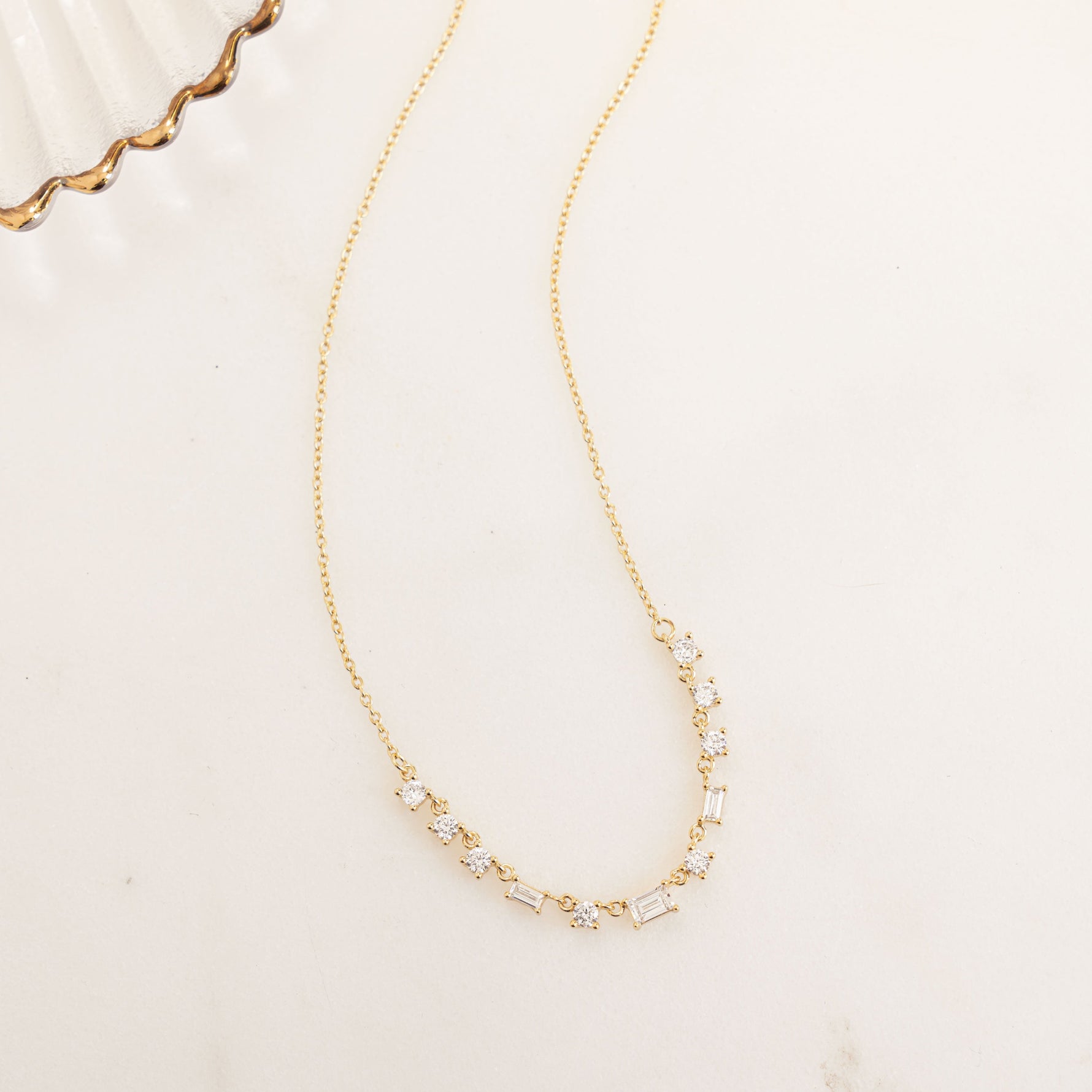 Closeup flatlay image of minimalist gold necklace with delicate cubic zirconia diamonds 