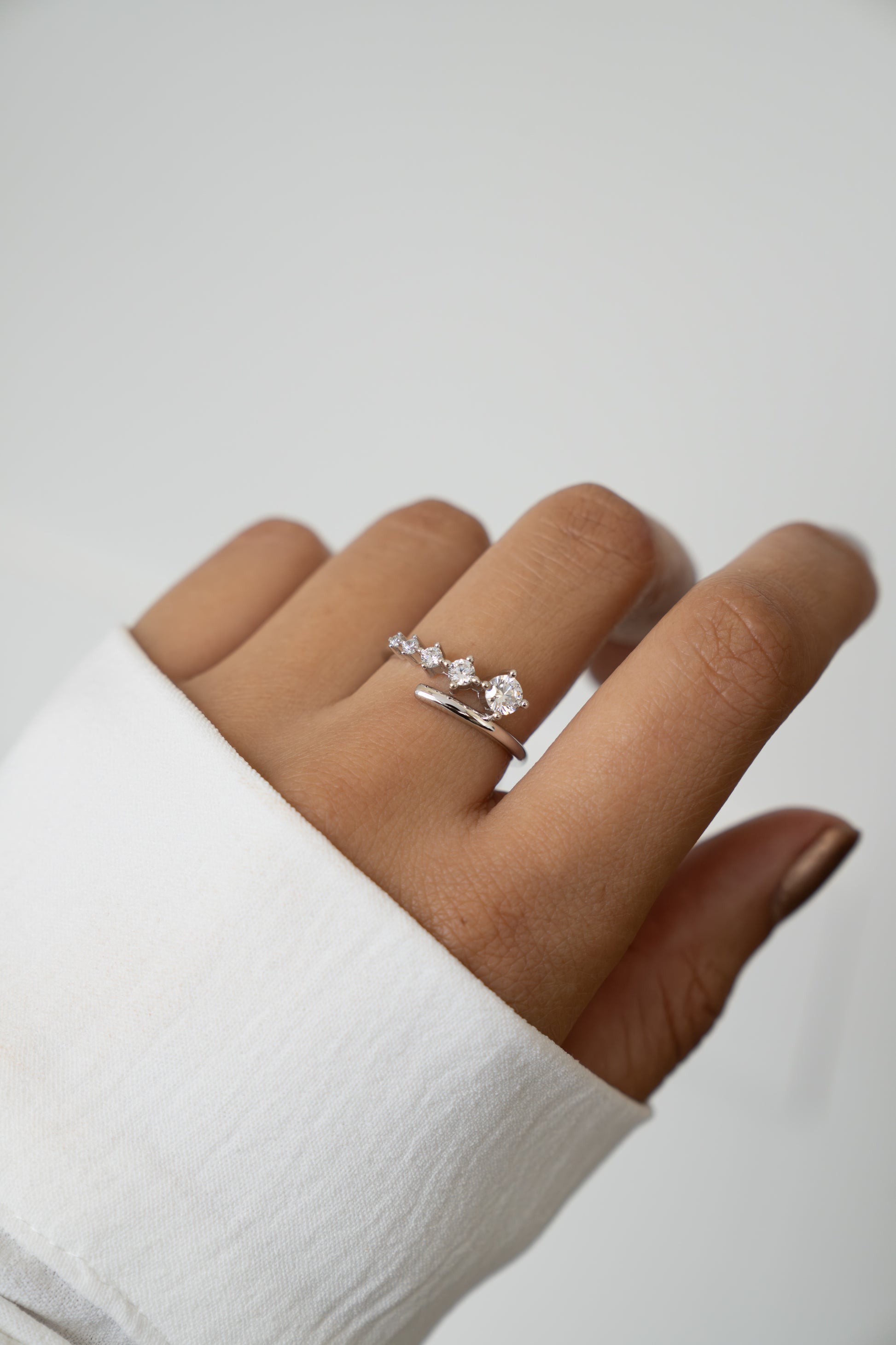 Sami Jewels 925 Sterling Silver Bypass Ring with 5 CZ diamonds on a person's finger against a white background