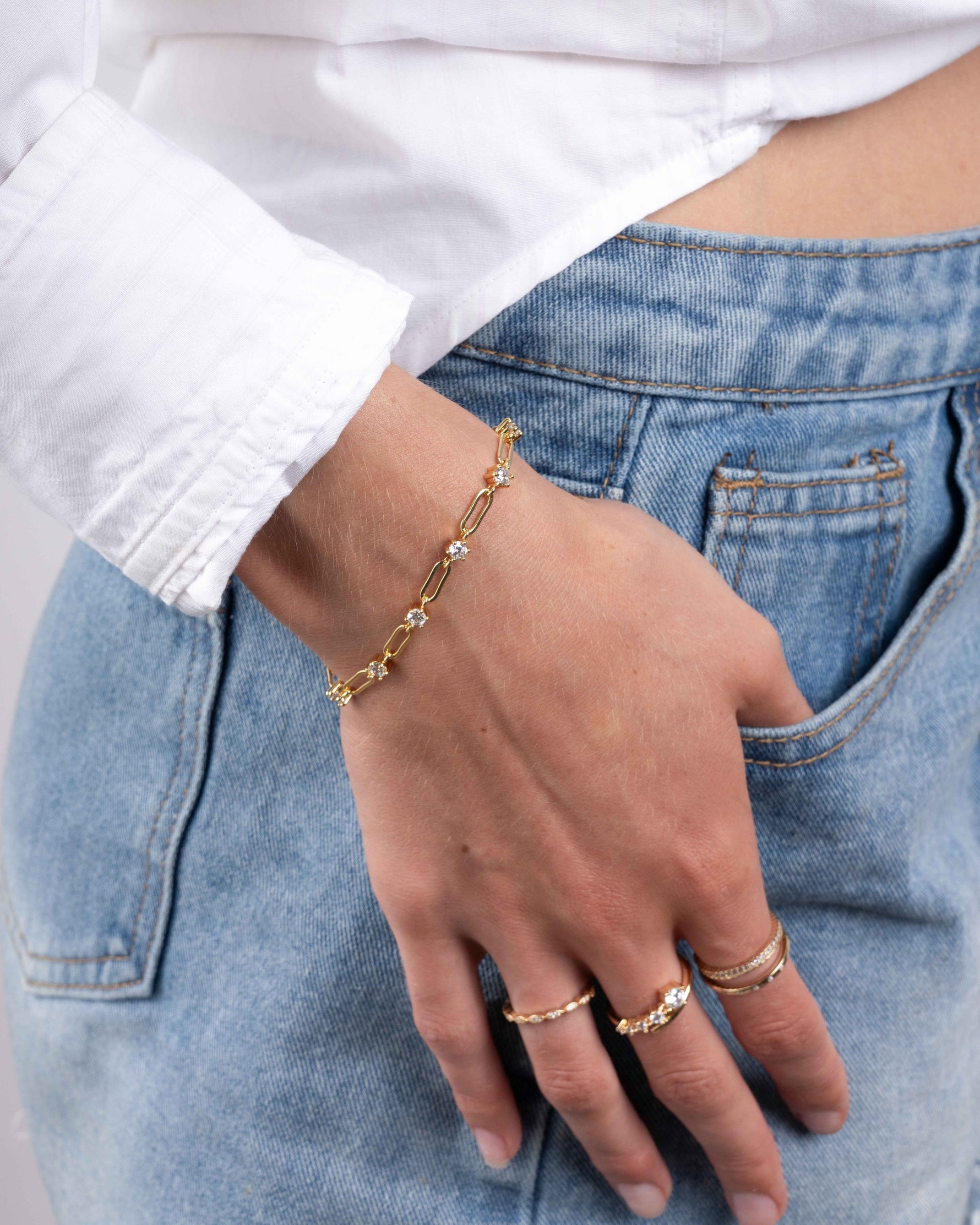 Gold gemstone bracelet on model with gold stackable rings