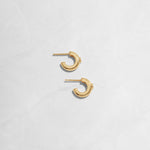 Closeup image of small gold diamond hoop earrings 
