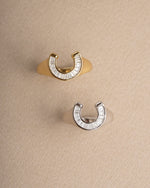 Statement jewelry featuring a gold and sterling silver horseshoe ring with a signet ring design
