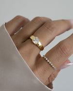 Model wearing gold stackable rings featuring a gold statement ring and a diamond stacking ring