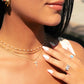 model wearing gold necklace stack featuring a cubic zirconia cross pendant necklace