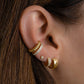 Model wearing gold earring stack featuring dainty cubic zirconia ear cuff
