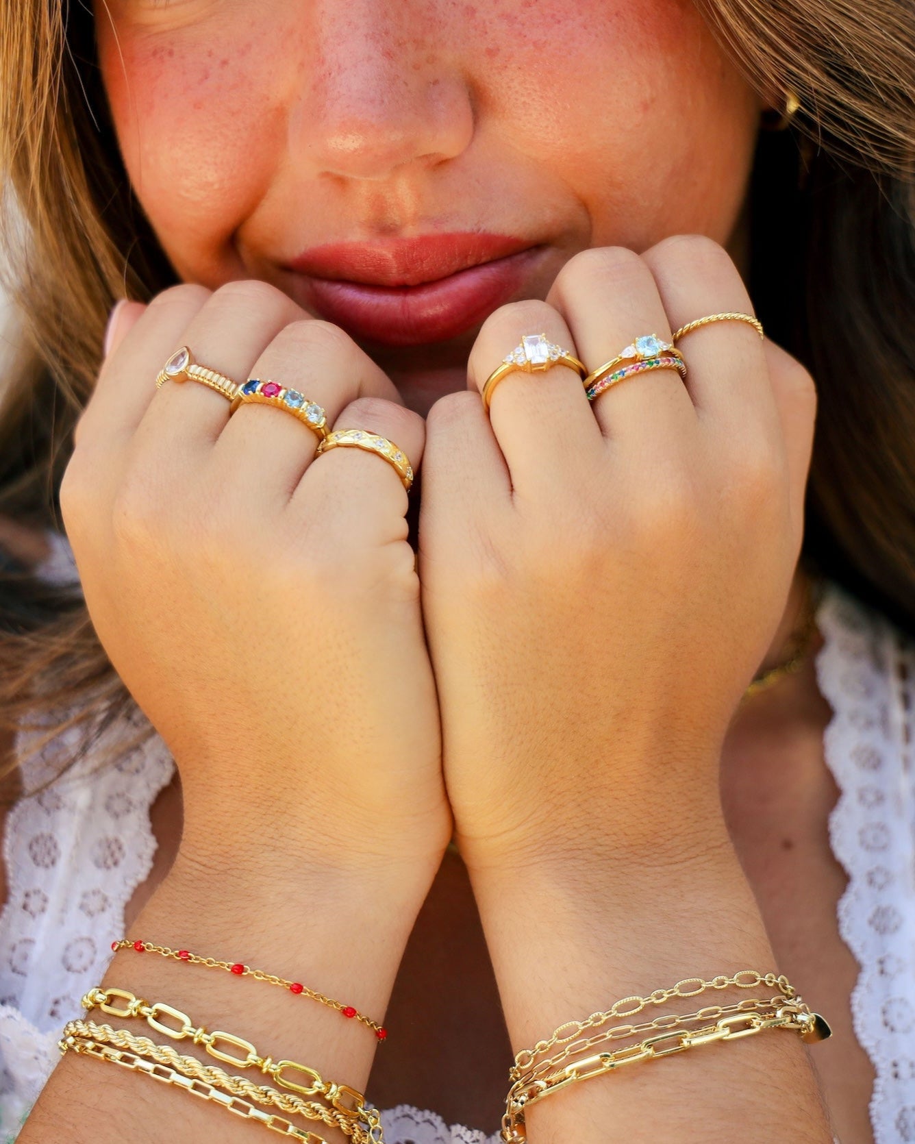 model wearing stacking rings and dainty stacking bracelets featuring a custom birthstone ring