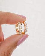 models hand showcasing mini gold studded hoop earrings