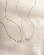 Two bridal necklaces, one gold chain and one silver chain with a teardrop diamond pendant