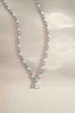 Silver holiday gift tennis necklace on a beige background