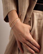 model wearing dainty bracelet stack featuring a baguette and solitaire diamond bracelet and a 3mm cz tennis bracelet