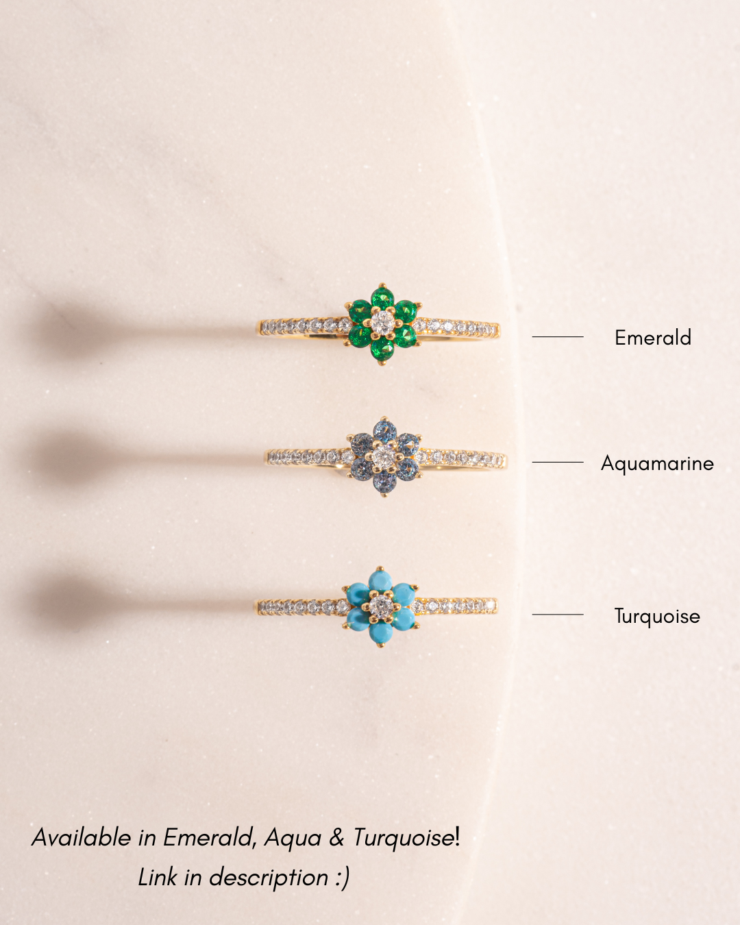 Three gold floral rings with gemstones labeled 'Emerald', 'Aquamarine', and 'Turquoise' on a beige background.
