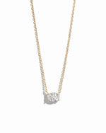 Gold necklace with a oval shaped diamond pendant on a white background