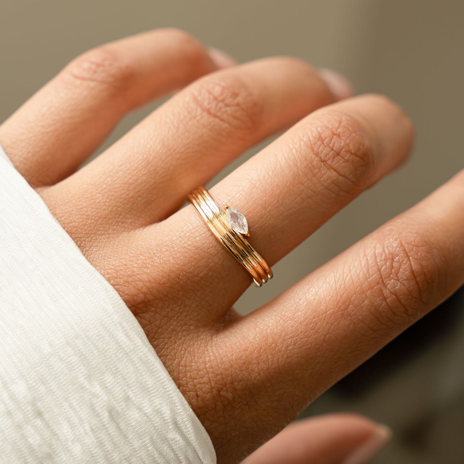 model wearing dainty gold ring featuring marquise stone