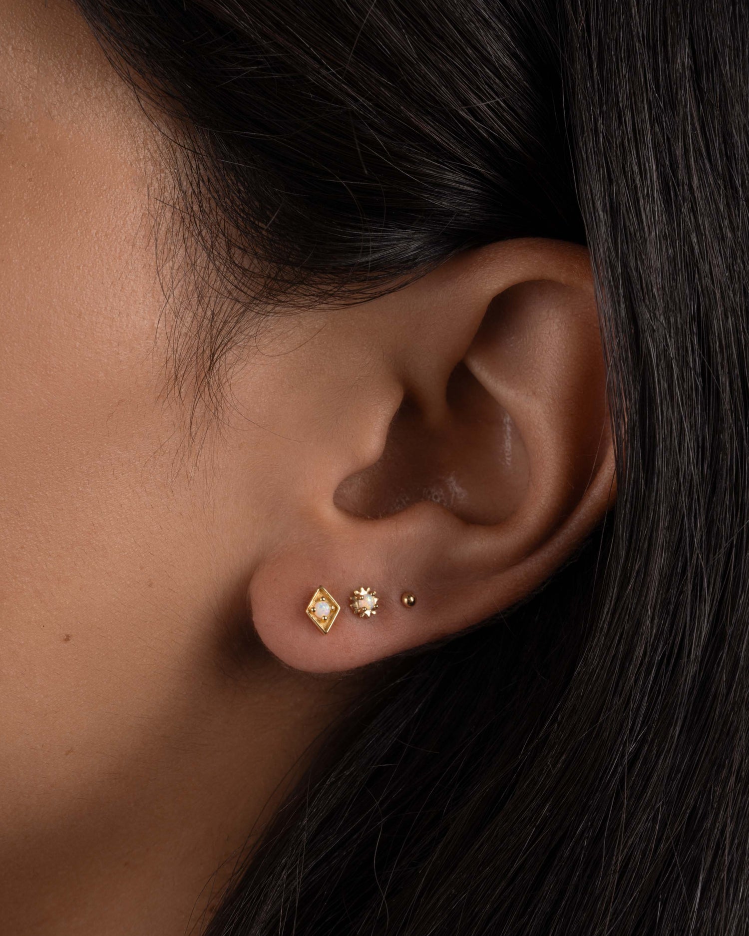 model wearing dainty opal kite shaped stud earrings.