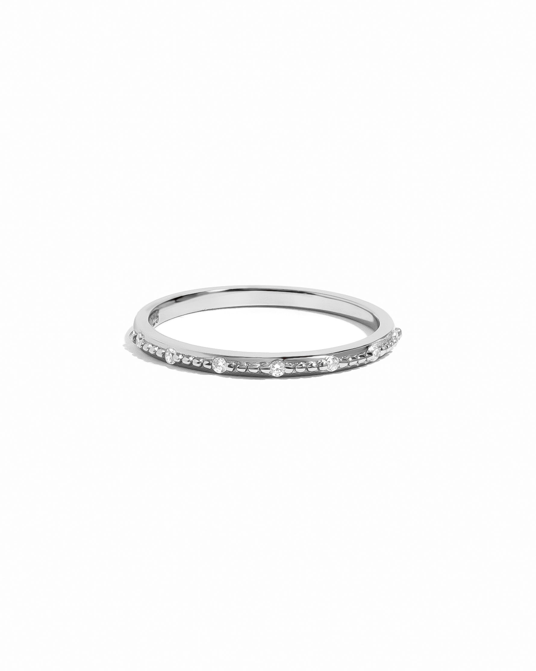 Silver ring with small cubic zirconia stones on a white background