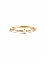 Gold ring with a small opal gemstone on a white background