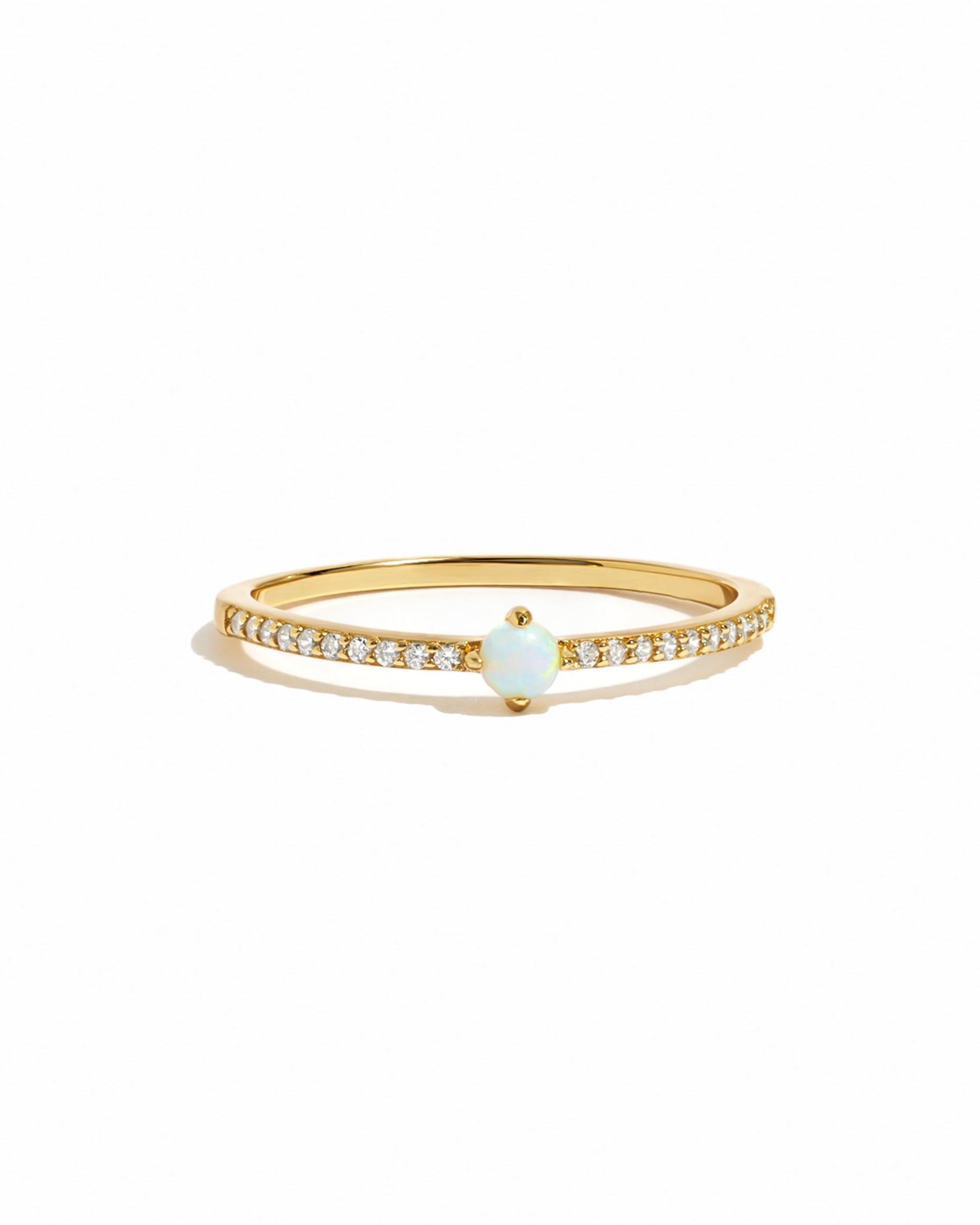 Gold ring with a small opal gemstone on a white background