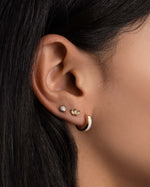 Dainty opal earrings worn on model.