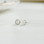 Closeup of silver pearl stud earrings
